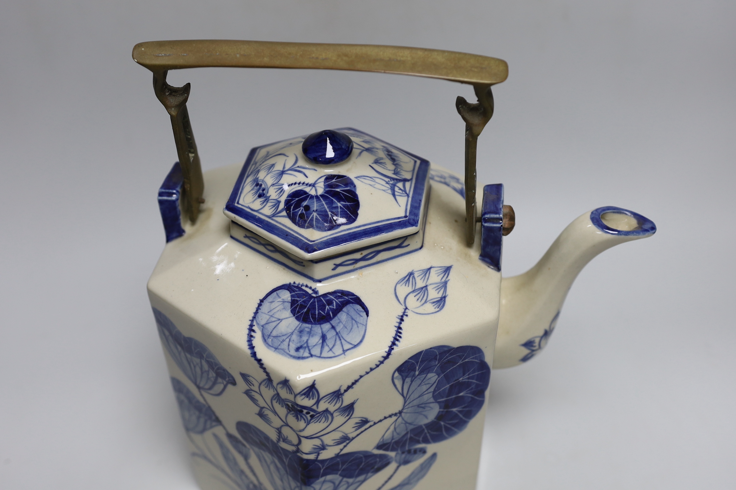 A Chinese blue and white oversized hexagonal teapot, with brass fitted handle and floral decoration, 30cm tall